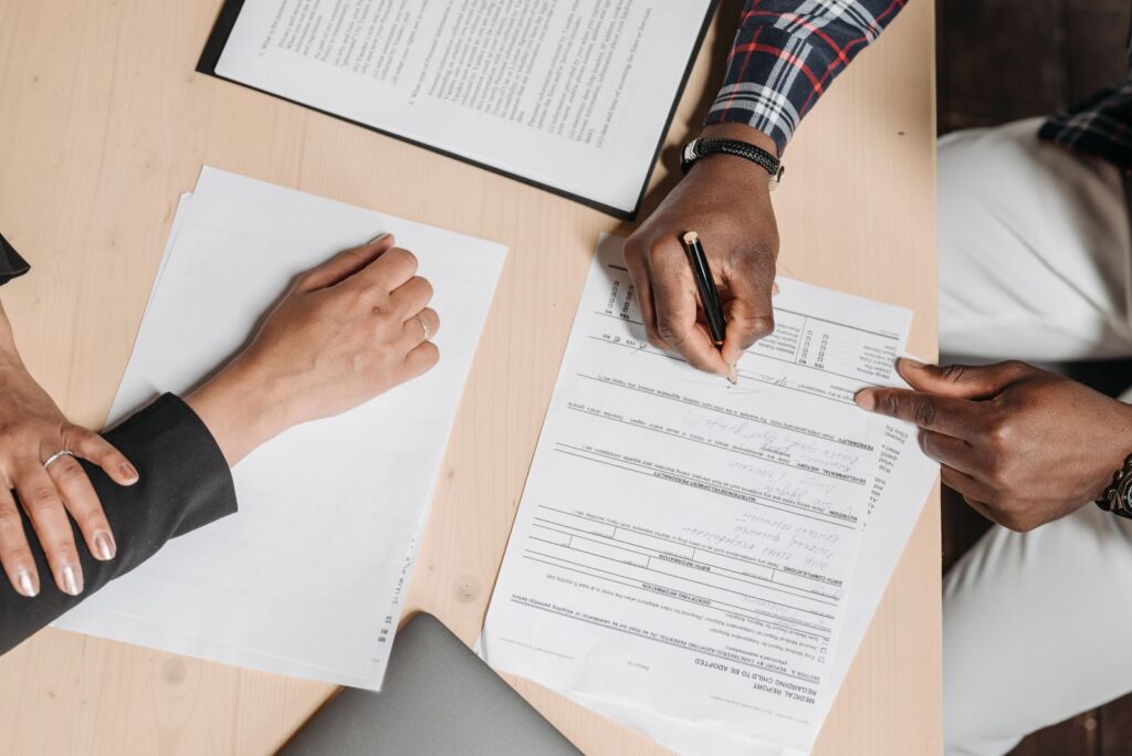 People reviewing and signing documents at a desk