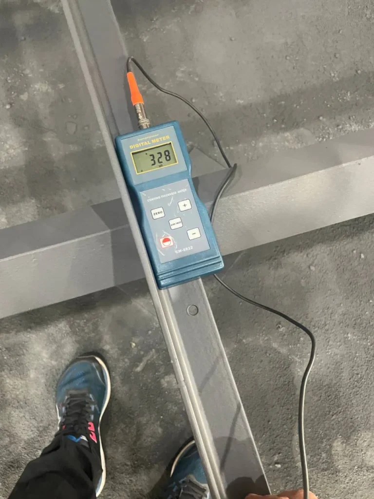Digital coating thickness gauge measuring the paint on a steel section
