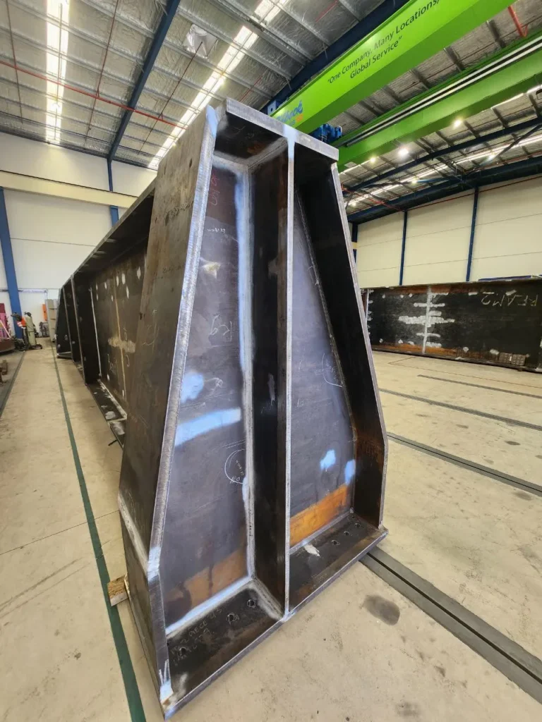 Large welded steel girder in a fabrication shop ready for final inspection